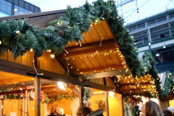 POS for market stalls at a Christmas market, with a festive wooden stall decorated with evergreen garlands and warm fairy lights.